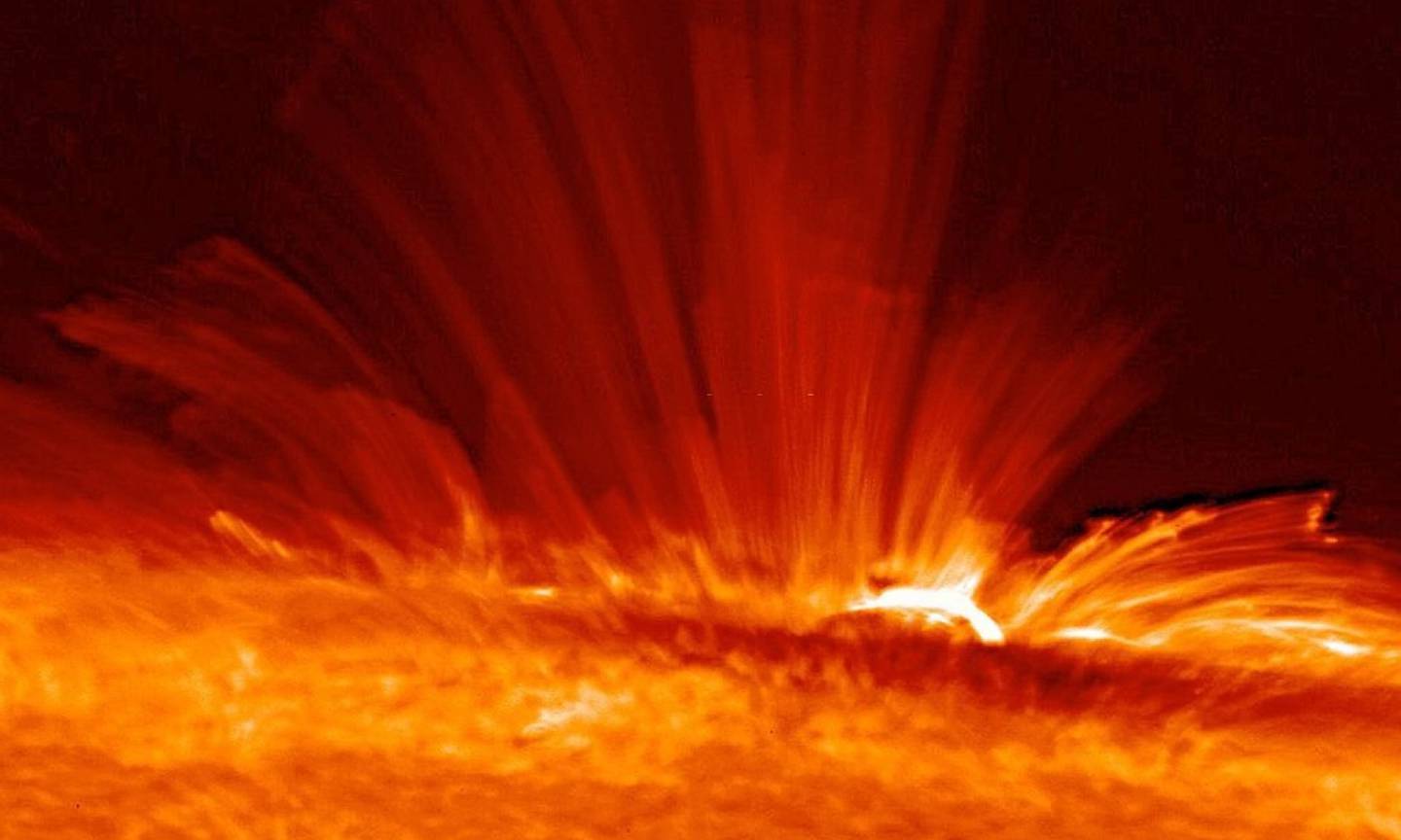 Mancha solar con serpentinas de gas (plasma) súper caliente cargado eléctricamente desde la superficie del Sol
