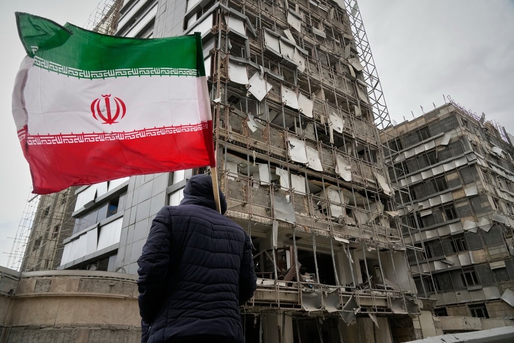 Un hombre sujeta una bandera iraní tras un ataque en Teherán, Irán, el 2 de marzo del 2026.