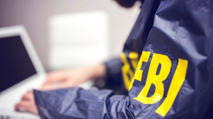 Policeman using laptop in office