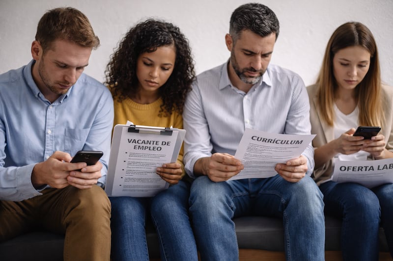 Personas buscando empleo con hojas de vida en sus manos