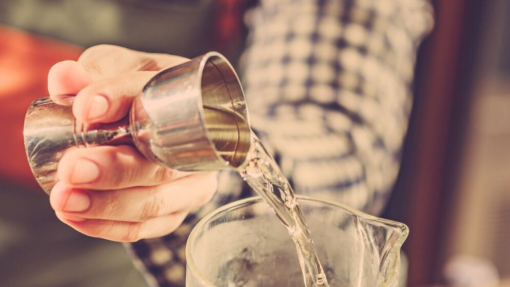 Barman haciendo un cóctel alcohólico en el mostrador del bar