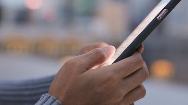 Un usuario revisa su dispositivo inteligente (smartphone).