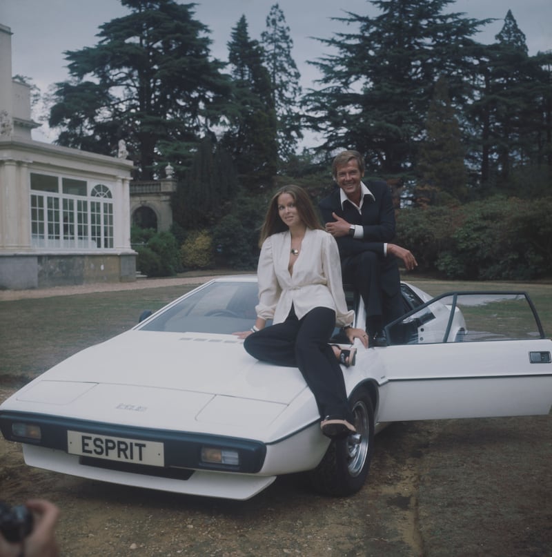 Los actores Barbara Bach y Roger Moore posan con el Lotus Esprit anfibio de la película The Spy Who Loved Me de 1977.