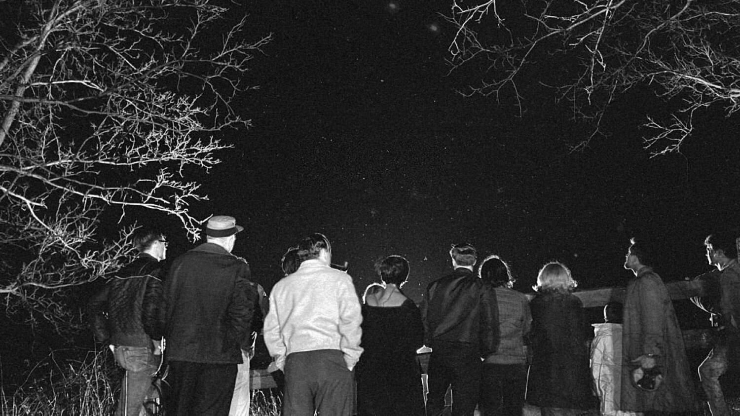 Un grupo de personas observa el cielo nocturno, tras el presunto avistamiento de un OVNI