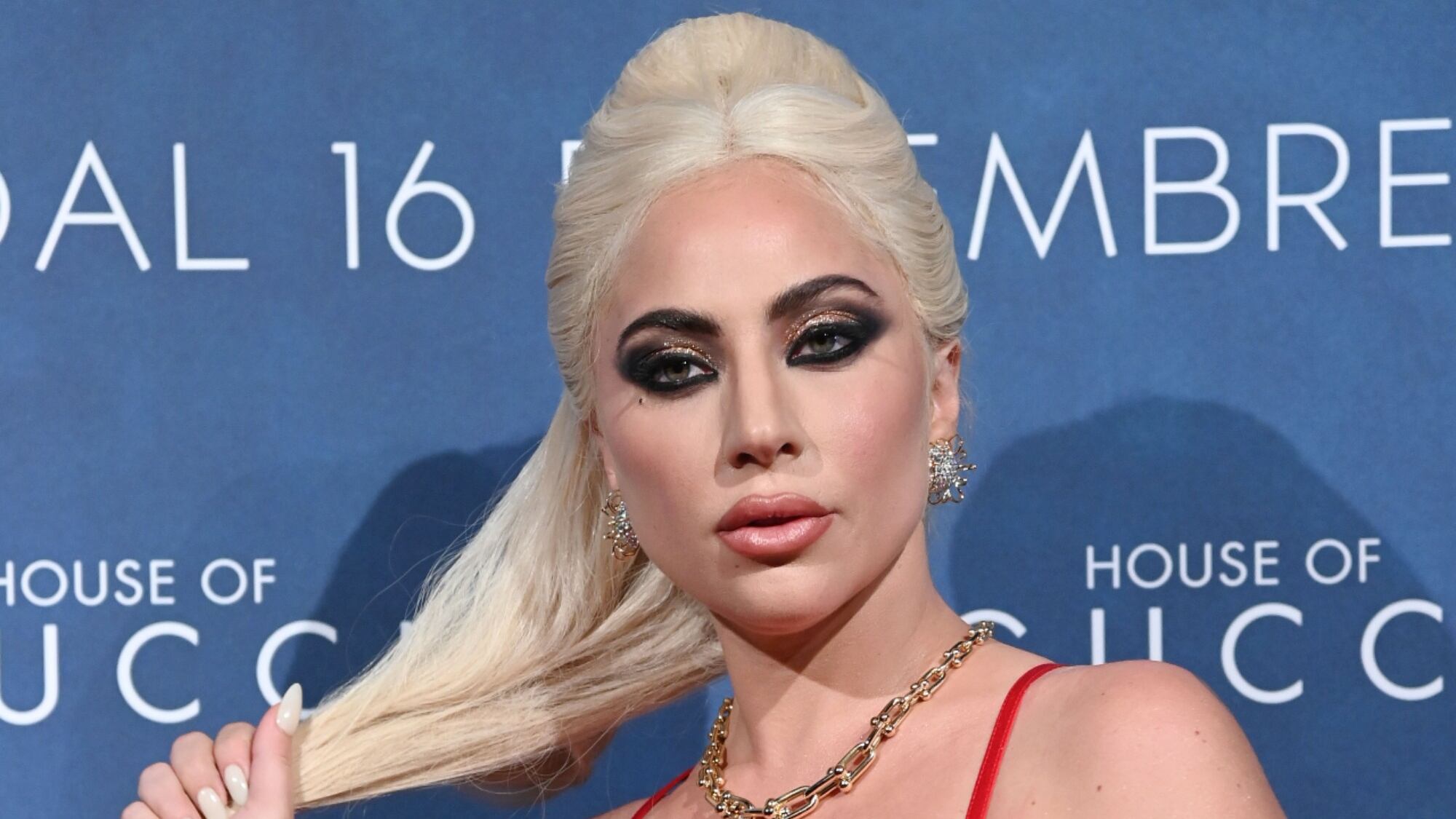 Lady Gaga en la presentación de House of Gucci, tomándose el cabello.