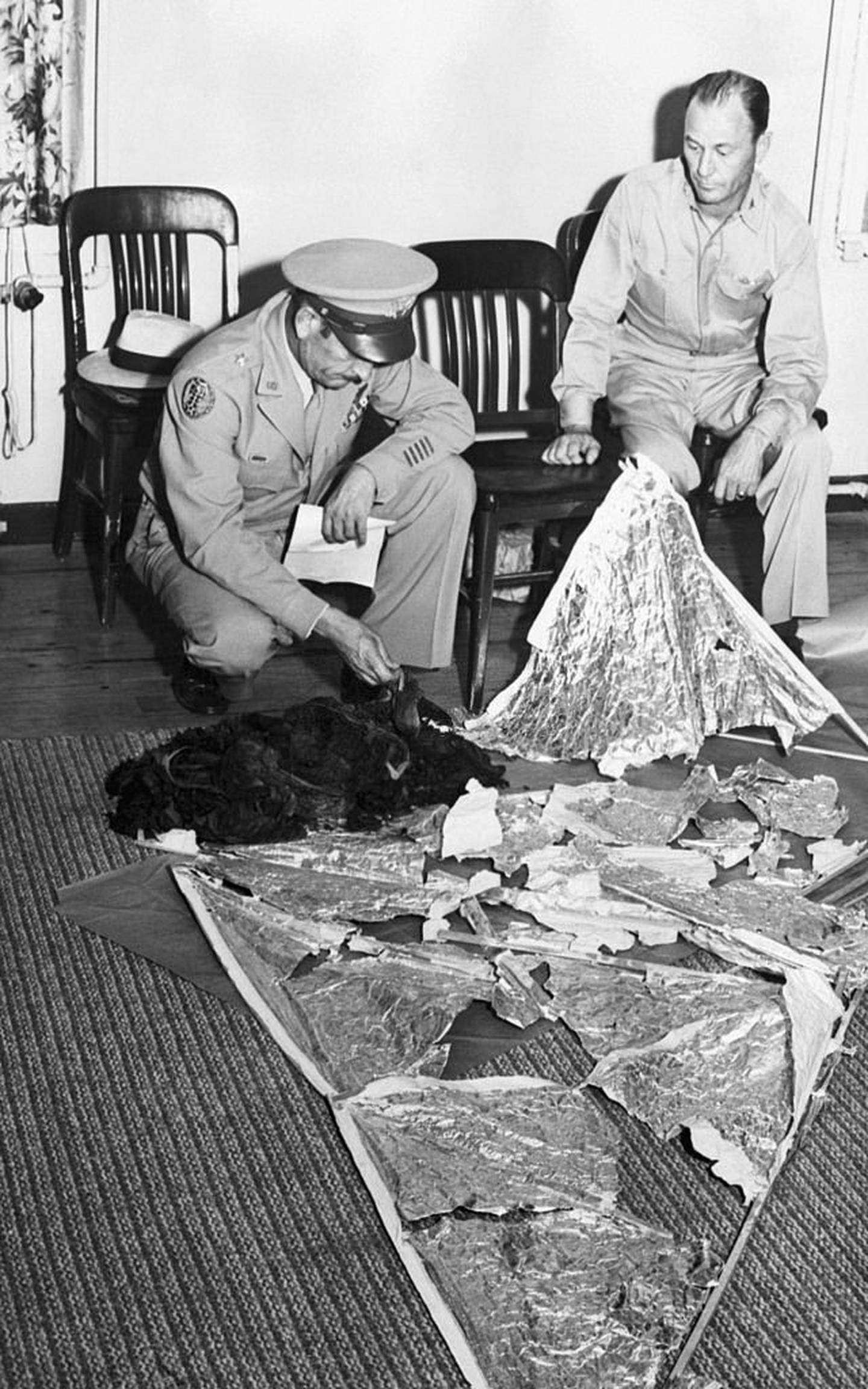 El Brigadier General Roger M Ramey y el coronel Thomas J Dubose identifican fragmentos del objeto encontrado en Roswell